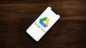 Google Drive Interface On Wooden Table Wallpaper