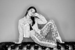 Grayscale Charli Damelio On Couch Wallpaper