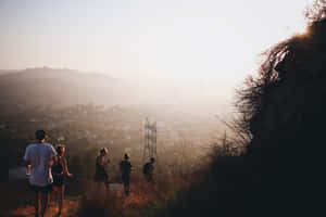 Group Of Friends Going Down The Mountain Slope Wallpaper