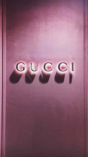 Gucci Logo On A Pink Wall Wallpaper