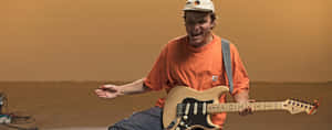 Guitaristin Orange Shirt Performing Wallpaper