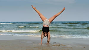 Gymnastics Handstand At Seashore Wallpaper