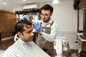 Hairdresser With Apron Performing Haircut Wallpaper