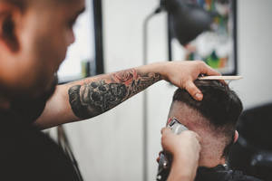 Hairdresser With Tattoo Doing Haircut Wallpaper