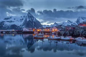 Hamnøy Village Nestled Amidst Majestic Snowy Mountains Wallpaper