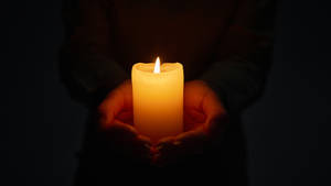 Hand Holding Condolence Candle Wallpaper