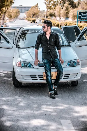 Handsome Boy Sitting On Car Hood Wallpaper