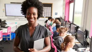 Happy African Teacher In Computer Class Wallpaper
