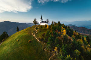 Hilltop Church Overlooking Scenic Countryside Landscape Wallpaper