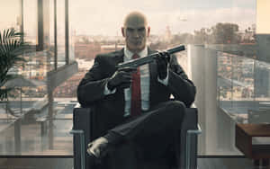 Hitman Agent 47 Holding Gun While Sitting Wallpaper