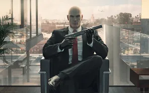 Hitman Agent 47 Holding Gun While Sitting Wallpaper