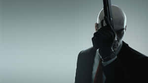 Hitman Holding Up Gun Desktop Wallpaper