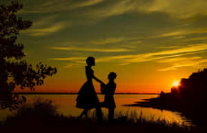 Husband And Wife Dancing By Lake Sunset Wallpaper