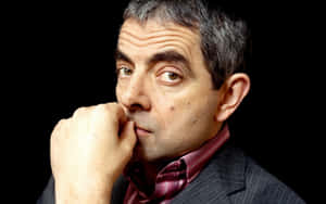 Iconic Actor Rowan Atkinson Posing On Red Background Wallpaper