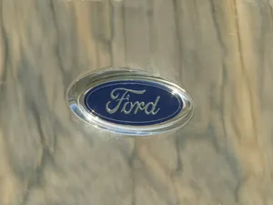 Iconic Ford Logo On A Stunning Blue Metallic Background Wallpaper