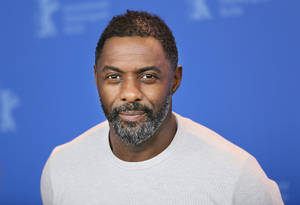 Idris Elba Against Blue Backdrop Wallpaper