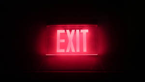 Illuminated Exit Sign Displayed On Black Tablet Screen Wallpaper