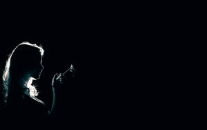 In The Shadows: Mysterious Lady Engulfed In Darkness Seeking Light Wallpaper