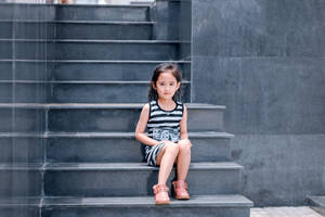 Innocent Glance - Adorable Girl On Grey Stairway Wallpaper