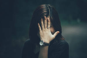 Insecure Woman Hiding Behind Hand Wallpaper