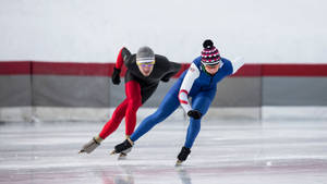 Intense Competition On Ice: Speed Skaters In Action Wallpaper