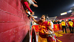 Intensity On Field - Usc Football Player In Action Wallpaper