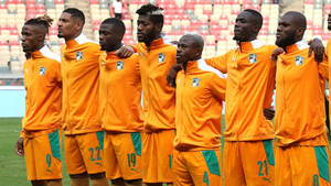 Ivory Coast Players In Orange Jacket Wallpaper