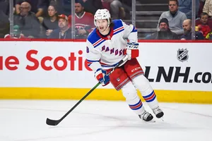 Jacob Trouba From New York Rangers Leaning To The Right While Holding Hockey Stick Wallpaper