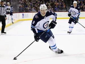 Jacob Trouba Leaning To The Right While Holding Hockey Stick Wallpaper