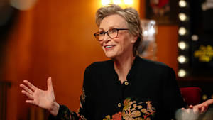 Jane Lynch On A Talk Show Smiling Wallpaper