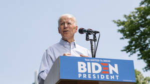 Joe Biden Giving Speech On Stage Wallpaper