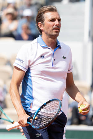 Julien Benneteau In Action- View Of French Tennis Player, Julien Benneteau, Serving During A Match, Wearing A White Polo Shirt. Wallpaper