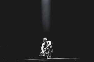 Kanye West Kneeling Under Light Wallpaper