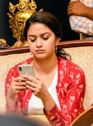 Keerthi Suresh Using Phone Hd Wallpaper