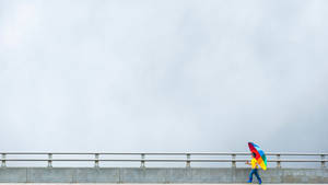 Kid Journey With Colorful Umbrella Wallpaper