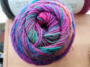 Knitting Dreams: A Close-up Image Of A Ball Of Yarn Wallpaper