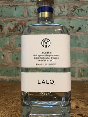 Lalo Tequila Bottle Against Brick Background Wallpaper