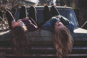 Lesbian Couple Laying On Truck Wallpaper