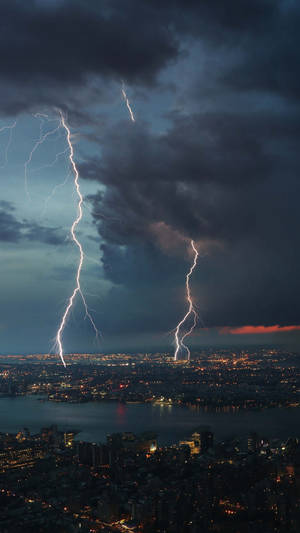 Lightning Strikes Over A City At Night Wallpaper