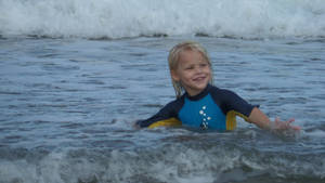 Little Boy Swimming In Beach Wallpaper