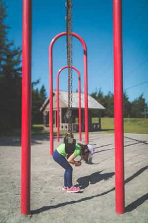 Little Girl On Playground Swing Wallpaper