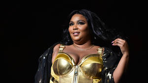 Lizzo Black And Gold Outfit Wallpaper