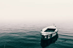 Lonely Boat Drifting On Rippled Water Wallpaper