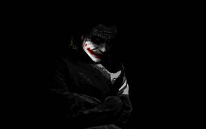 Lonely Joker In Shadows Wallpaper