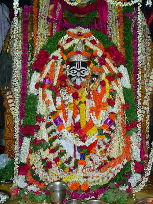 Lord Lakshmi Narasimha Statue Covered In Garlands Wallpaper