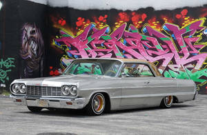 Lowrider Impala Against Colorful Mural Wallpaper