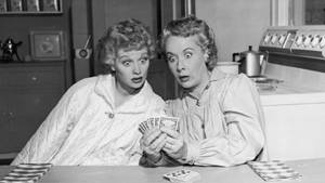 Lucille Ball And Vivian Vance Engaged In A Friendly Card Game Wallpaper