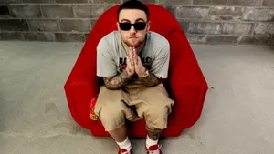 Mac Miller 4k In A Red Chair Wallpaper