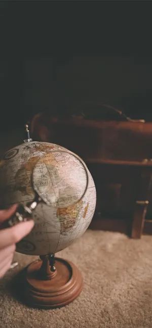 Magnifying Glass On A Mini Globe Wallpaper