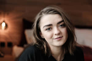 Maisie Williams Posing Elegantly In A Green Dress Wallpaper